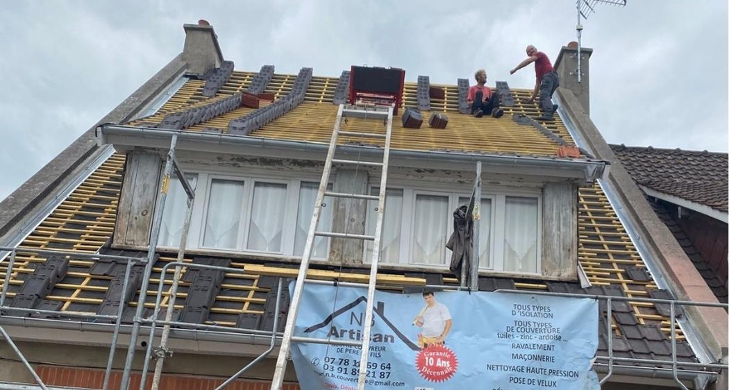 Pose de tuiles sur une toiture avec échafaudage